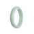 A stunning oval-shaped Burmese Jade bangle bracelet with a pale green color and subtle hints of lavender. The bracelet is made from genuine Grade A jade and measures 58mm in size. Perfect for adding an elegant touch to any outfit.