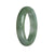 A half-moon shaped green jadeite bangle, crafted from genuine natural jadeite.