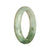A close-up image of a white and light green patterned jade bracelet in the shape of a half moon, measuring 54mm.