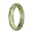 A beautiful half-moon shaped jade bangle with a green and white pattern, made from genuine Grade A Burma jade.