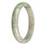 A close-up image of a jade bangle with a white base color and a green pattern. The bangle features apple green and lavender spots, giving it a unique and vibrant appearance. The bangle has a half moon shape and measures 79mm in diameter. It is an authentic Type A Burma jade piece.
