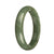 A half-moon shaped green jadeite jade bangle bracelet, showcasing the natural beauty of the stone.
