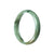 A close-up image of a beautiful green jadeite jade bangle bracelet with a half moon shape, measuring 57mm in size. The bracelet is certified as Grade A quality, showcasing its exceptional craftsmanship and stunning color. The brand name "MAYS" is engraved on the inner side of the bracelet.